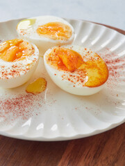 Close up view hard boiled eggs, peeled and cut in halves with olive oil and paprika on top. Healthy meal, protein food.
