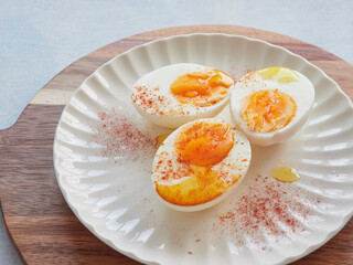 Healthy and protein food. Hard boiled eggs with olive oil and paprika on top.