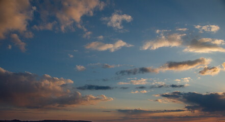 Russia. South of Western Siberia. The clouds illuminated by the setting sun in the evening sky over the endless fields of Altai.