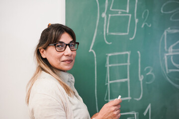 Latin female teacher smiling on camera inside classroom - Mature woman working inside university...