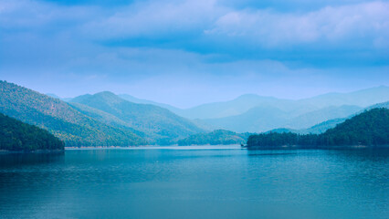 Naklejka premium Beautiful intricate landscape, mountain lake view on sky cloudy background.