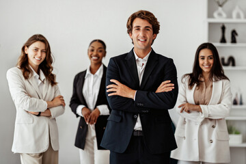 Successful business team. European businessman standing with folded arms in front of his employees, posing in office