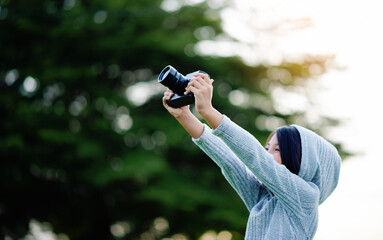 Take pictures with a mirrorless camera. Little girl practicing nature photography little photographer the joy of taking pictures