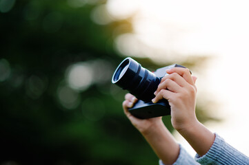 Take pictures with a mirrorless camera. Little girl practicing nature photography little photographer the joy of taking pictures