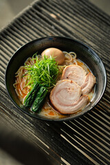 Delicious bowl of ramen soup on black chair