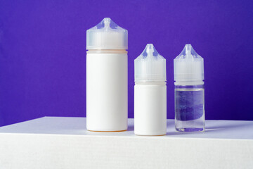 Electronic cigarettes liquid bottles on purple background