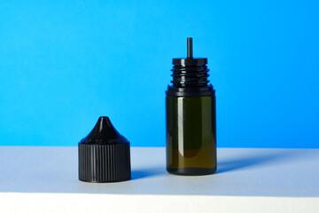 Black electronic cigarettes liquid bottle on blue background