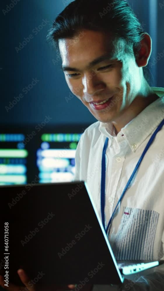 Poster vertical video computer scientist strolling through server rows providing processing resources for d