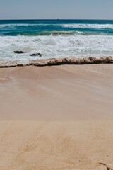 Beautiful waves of the ocean wash the sandy beach.