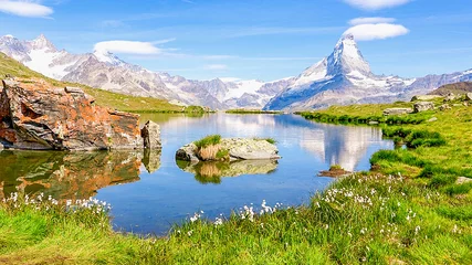 Zelfklevend Fotobehang Souvenir de randonnée en altitude dans les Alpes avec un petit lac d'alpage en montagne avec le reflet des sommets enneigés en d'altitude © Bernard