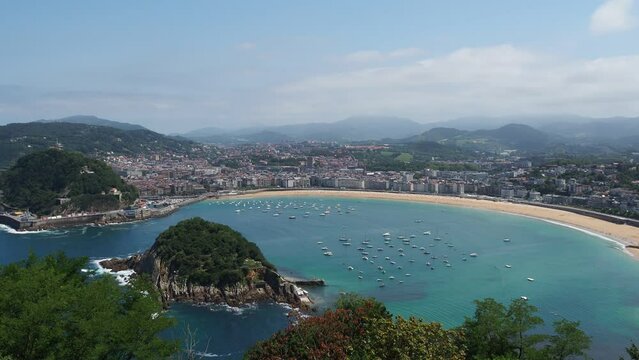 Panoramic view of La Concha beach in the Basque city of San Sebastian with sailboats. Summer tourist destination seascape.
