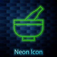 Glowing neon line Mortar and pestle icon isolated on brick wall background. Vector