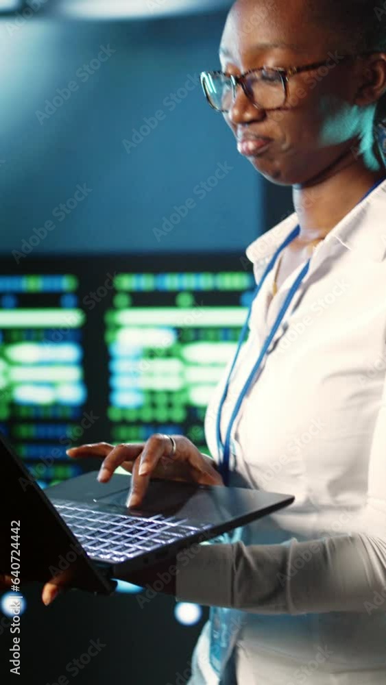Poster vertical video focused it consultant strolling through server rows providing processing resources fo