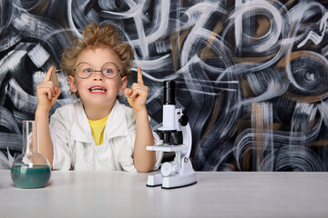 Boy in the bathrobe smiles happily, raised his fingers up, he had a brilliant idea. Cheerful child...