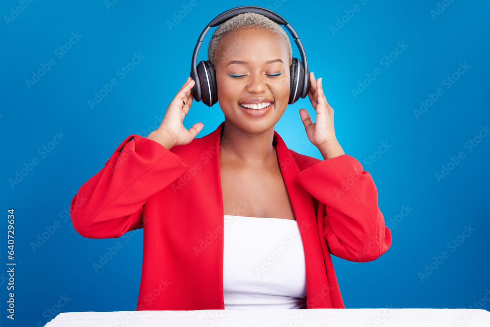 Canvas Prints Music, headphones and black woman dance in studio celebration with news, feedback or promo on blue background. Freedom, happy and African model dancing to earphones radio, podcast or audio streaming