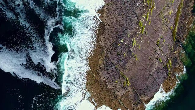Aerial view of waves crashing on a cliff in Ireland