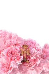 Wooden christian cross with pink carnations flowers close up on abstract white background. Symbol of the death and resurrection of Jesus Christ, Faith of God, Hope, Love. Religious church holiday