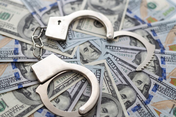 Handcuffs on money background, business security concept