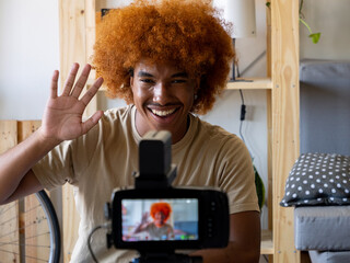 Young African American man performing live on the internet with a camera in an apartment. Digital content creator, streaming