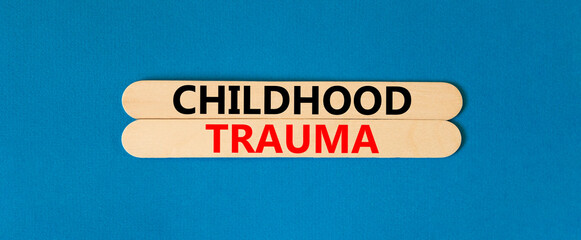 Childhood trauma symbol. Concept words Childhood trauma on beautiful wooden stick. Beautiful blue...