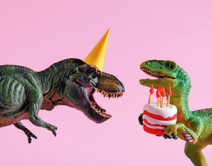 Cute happy green dinosaurs in birthday hats holding cake with flaming candles on pastel pink...