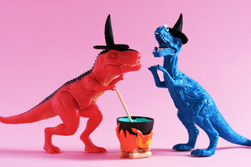 Two funny dinosaurs wearing witch hats are brewing potion in pot on pink background. Halloween...