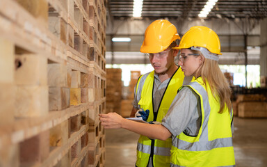 Both of workers work in a woodworking factory, Checking inventory the wood in the wooden warehouse