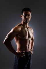 Fototapeta na wymiar Confidence, muscle and portrait of man on dark background for fitness inspiration, beauty aesthetic or strong body. Shadow aesthetic, male sports model or muscular bodybuilder in studio lighting.