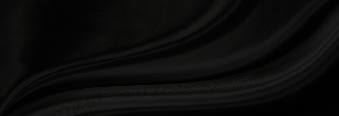 Black gray satin dark fabric texture luxurious shiny that is abstract silk cloth panorama background with patterns soft waves blur beautiful.