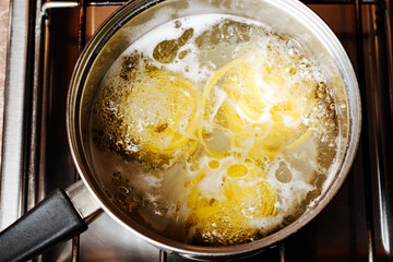 Tagliatelle pasta is cooked in a saucepan.