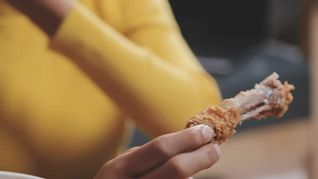Closeup image of a beautiful asian woman enjoy eating french fries and fried chicken in restaurant