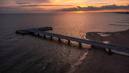 A pier at sunrise on the Baltic Sea. A sandy beach in Kolobřeh. Taken from a drone. Kołobrzeg is...