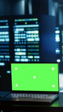 Vertical video Engineering coworkers using mockup laptop to implement artificial intelligence parallel processing. Adept colleagues work on green screen device, enabling AI systems to process machine