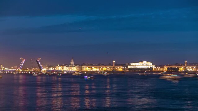 Timelapse of Palace Bridge opening and the iconic Spit of Vasilyevsky Island with the Old Stock Exchange. Numerous observing tourists, ships, and boats grace the Neva River at night. Saint-Petersburg