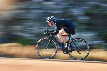 Motion blur, speed and cyclist on bicycle on road in mountain with helmet, exercise adventure trail and fitness. Cycling race, nature and man with bike for fast workout, training motivation or energy - Powered by Adobe