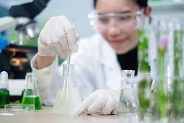 Scientist is focusing and stirring liquid or substance sample in plant, green, herbal or cosmetic...