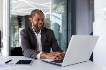 Successful mature african american businessman at work inside office, experienced boss working with...