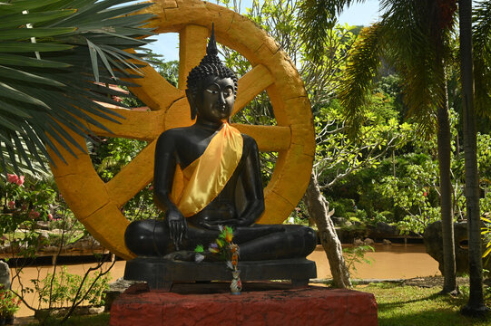 Seated black Buddha image, outdoor, enshrined inside Wat Tham Khao Wong temple.