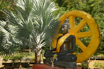 Seated black Buddha image, outdoor, enshrined inside Wat Tham Khao Wong temple.