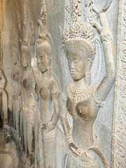 Fototapeta na wymiar The famous bas-relief of Apsaras, celestial maidens, with intricate hairstyles on the inside wall of the first floor of the Angkor Wat temple in Siem Reap, Cambodia.