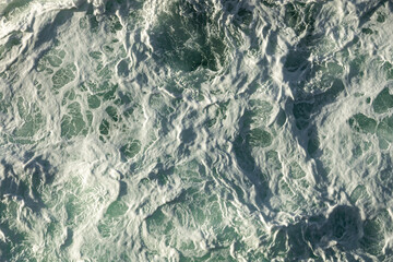 Turbulent ocean water on a blue green sea with foam and waves