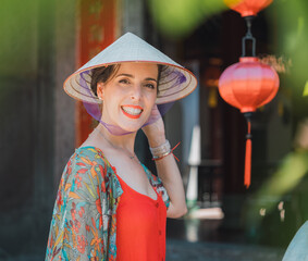beautiful caucasian woman smiles with a vietnamese cap