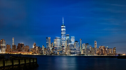 Lower Manhattan at night as seen from New Jersey. - obrazy, fototapety, plakaty