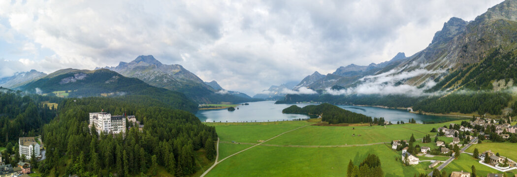 Aerial view over Lake Sils with morning fog and clouds and the Chaste island in Sils Maria / Segl, St Moritz, Canton Grisons, Switzerland