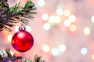 Fototapeta na wymiar Christmas decoration. Red balls hanging on pine branches Christmas tree garland and ornaments over abstract bokeh background with copy space
