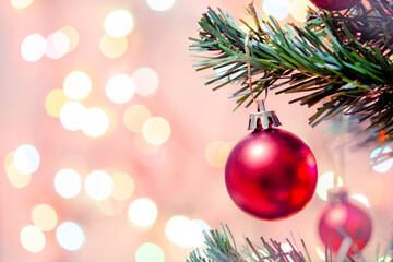 Christmas decoration. Red balls hanging on pine branches Christmas tree garland and ornaments over abstract bokeh background with copy space