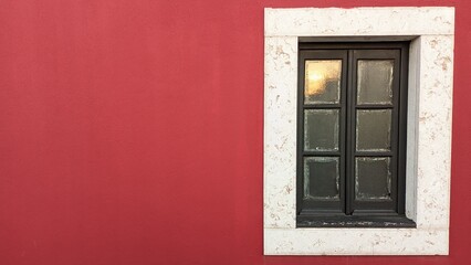 Wooden old window in an old castle with red walls and a stone window frame