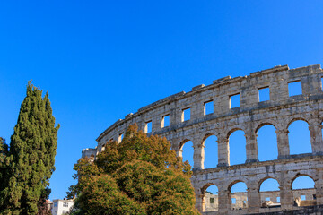 Fototapeta na wymiar The ruins of the Roman arena in the Croatian city of Pula under a blue sky on a sunny day