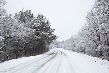 beautiful snow landscape: car road through the forest