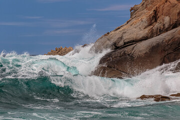 Wellen schlagen in einem Sturm an die Felsen der Küste